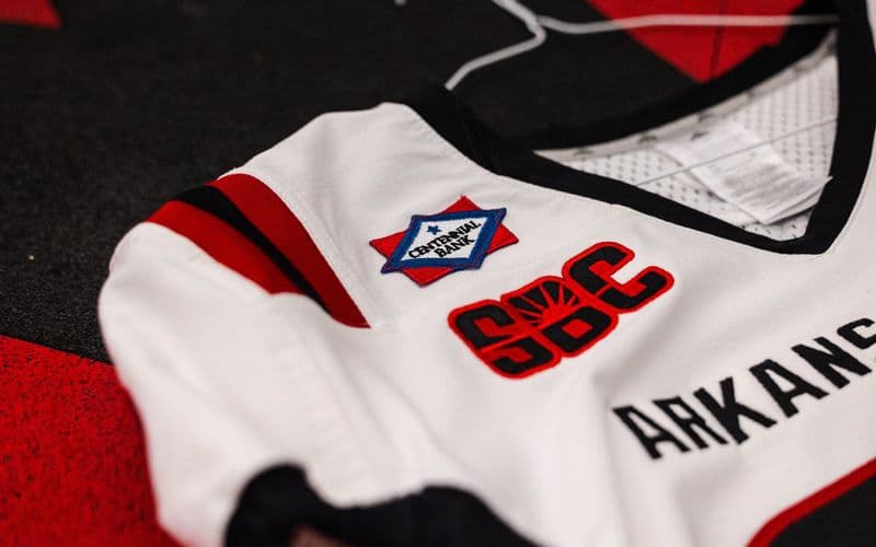 Close-up of the Centennial Bank patch stitched on the white Arkansas State Red Wolves football jersey, next to the Sun Belt Conference logo