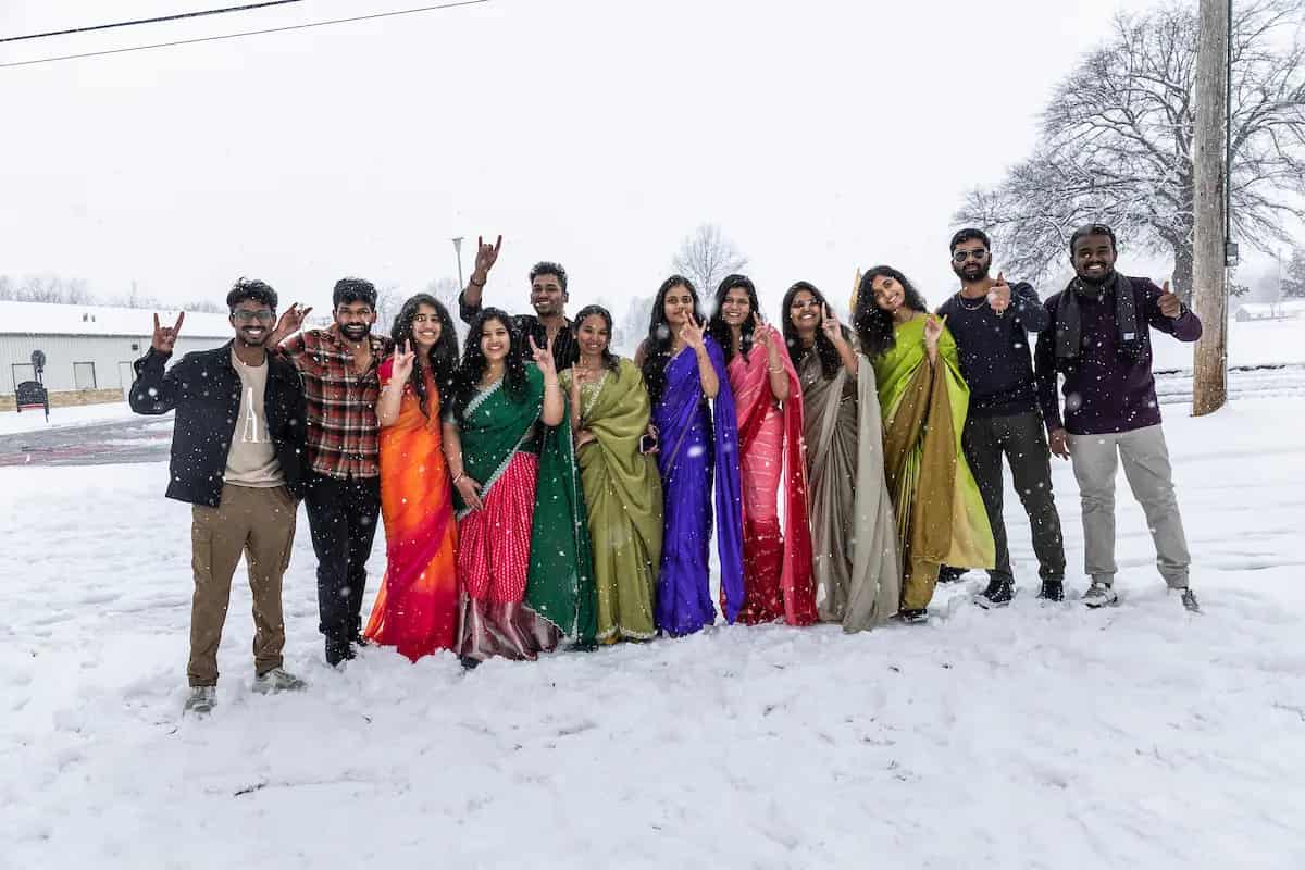 International students in traditional dress on a snowy A-State campus