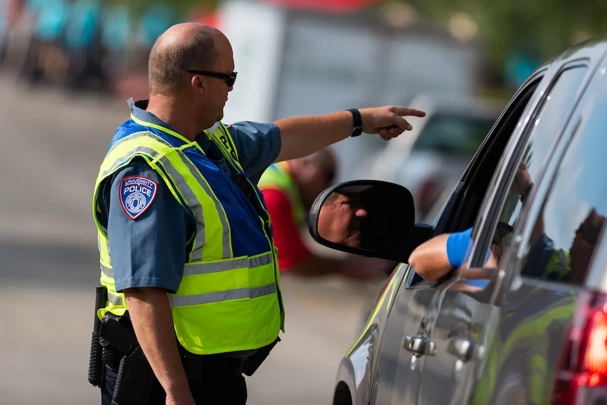 An Arkansas State University police officer directing traffic on residence hall move-in day